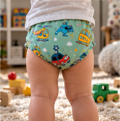 Toddler standing on a rug in green helicopter-print training underwear